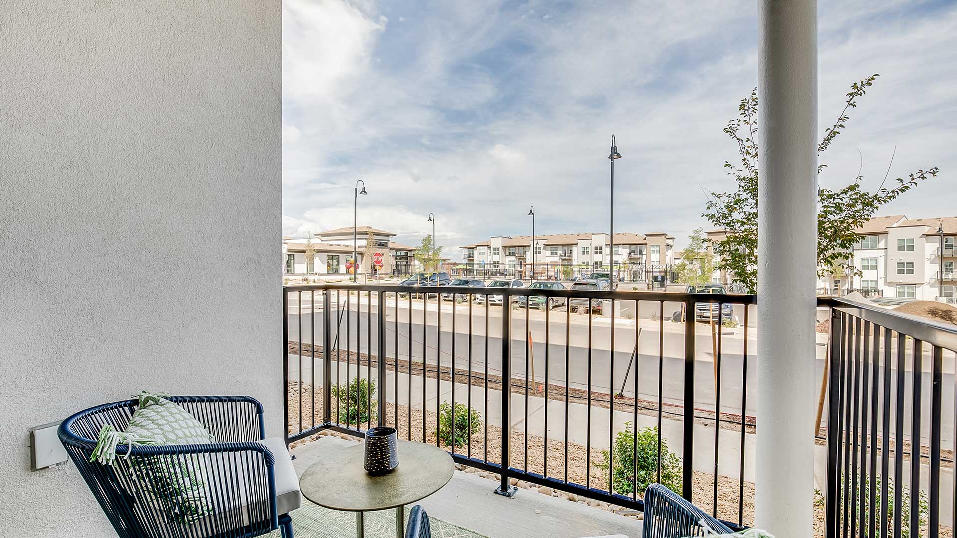Private apartment balcony at The Wright in Centennial featuring outdoor seating and views of the modern residential community.