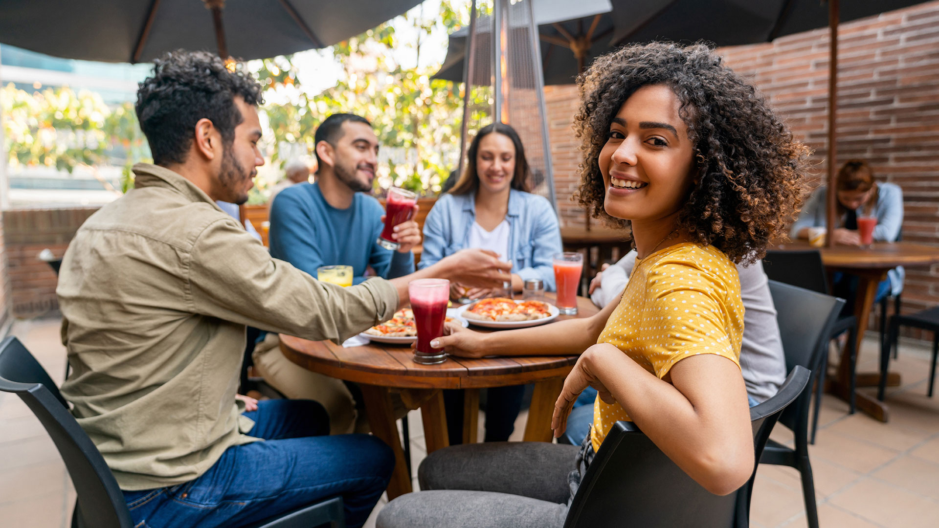 Friends dining together at an outdoor restaurant patio near The Wright, highlighting the neighborhood’s social atmosphere, dining options, and local lifestyle.